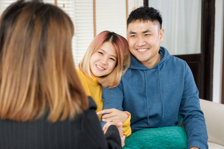 Asian couple getting key and handshake with realtor agent