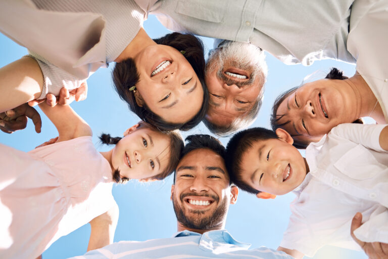 Low angle shot of a happy family huddled together outdoors